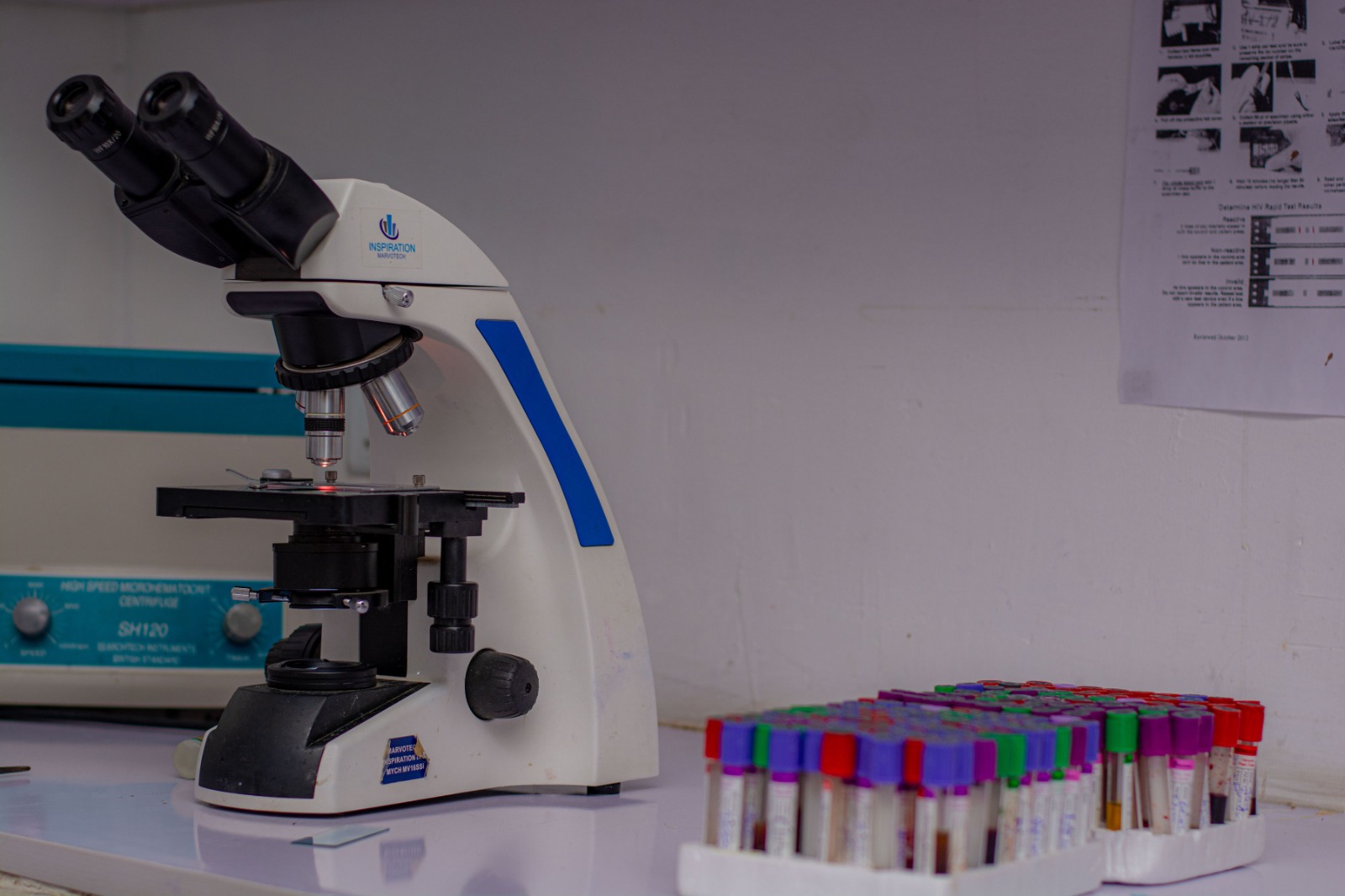 A microscope and racks of blood sample tubes in the Nuga Hospitals laboratory